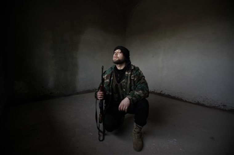 A Syrian rebel looks out after Syrian army tanks enter the northwestern city of Idlib, Syria, Tuesday. 